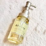 A pump bottle of &honey Silky Smooth Moisture Hair Oil lay in a soft white fur fabric.